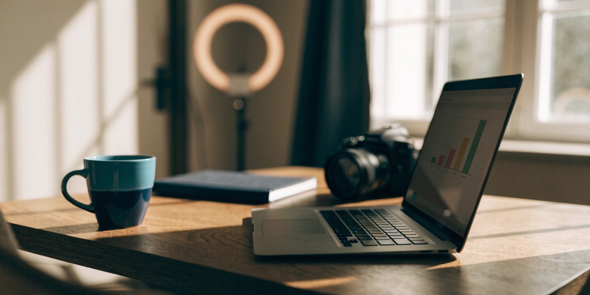 Home office desk with a laptop, camera, and ring light representing a creator business considering an S corp